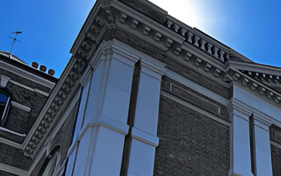 Photograph of the Town Hall at Whitechapel from a few meters away, looking up and across at the frontage