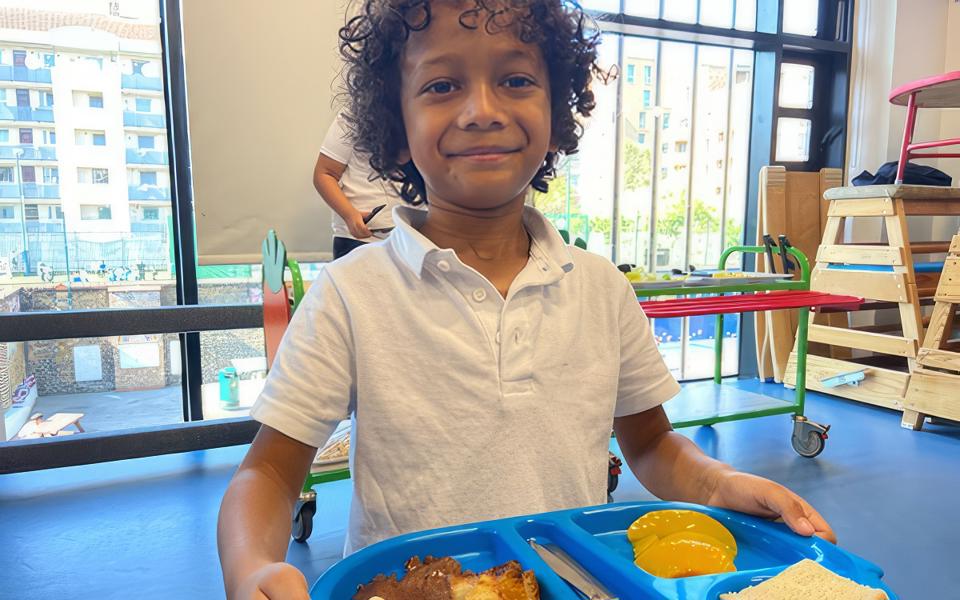 A youngster at school with a tray of food